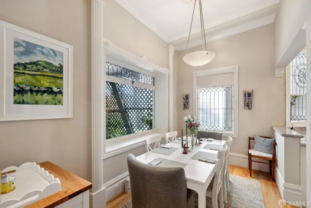 a view of a dining room with furniture a chandelier and wooden floor
