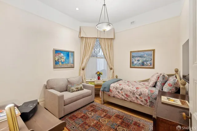 a bedroom with two beds and a chandelier
