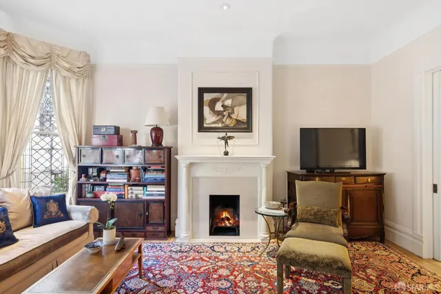 a living room with furniture a rug and a fireplace