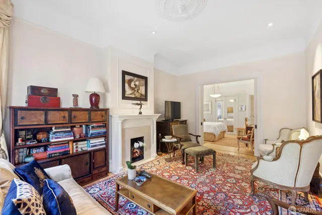 a living room with furniture a bookshelf and a fireplace