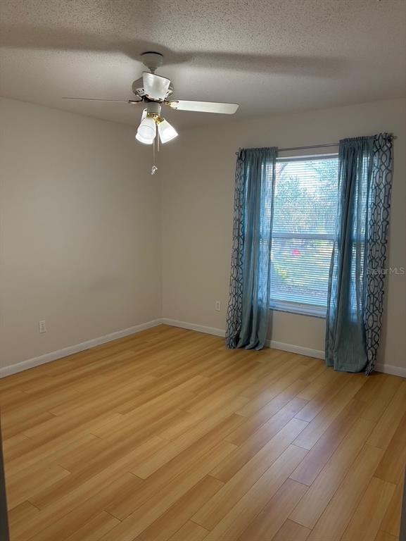 21425 Southwest Plantation Street Dunnellon, FL 34431 - Photo 34 of 54 an empty room with wooden floor fan and windows