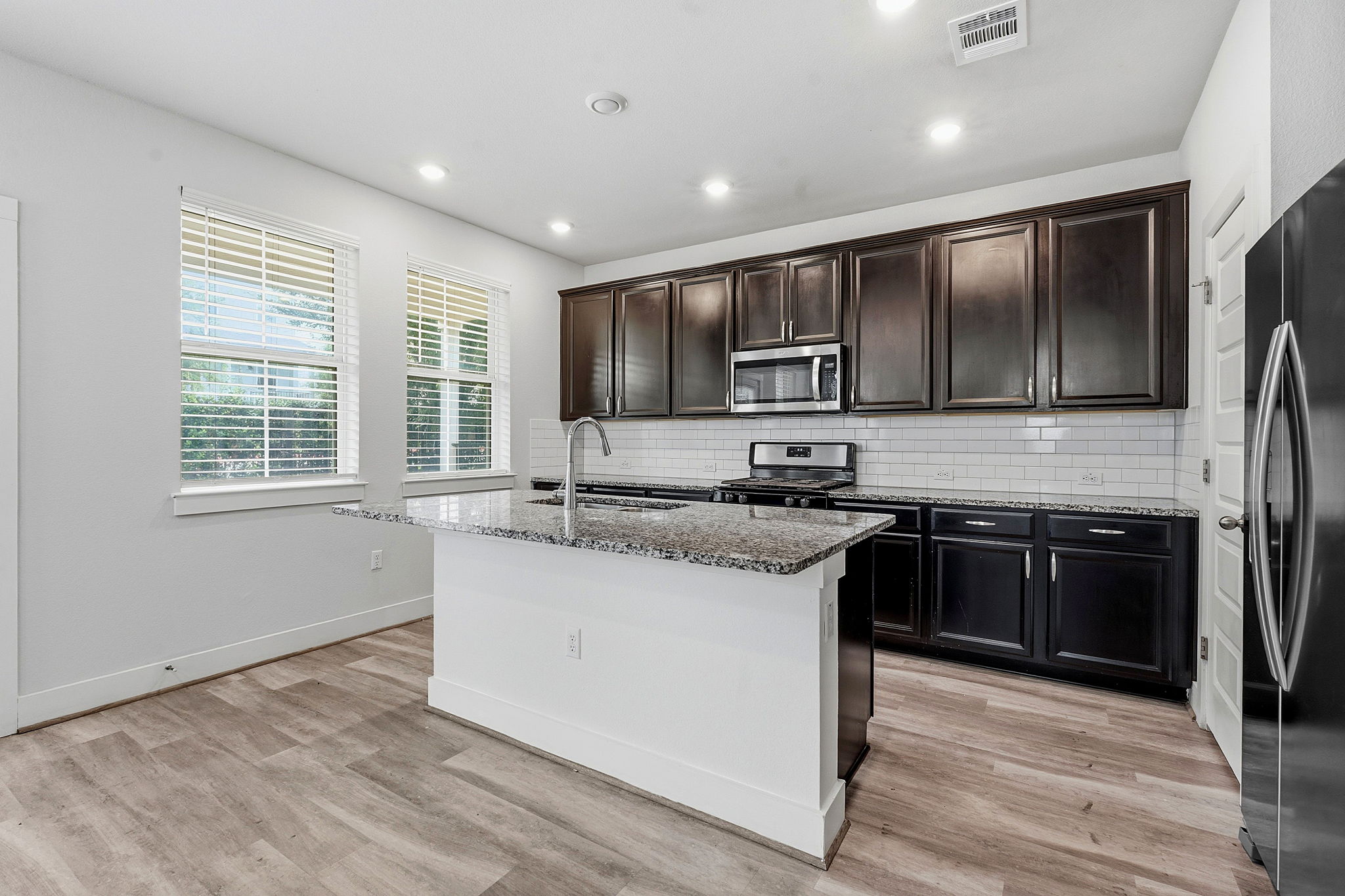 7105 Silver Star Lane, Unit 59 Austin, TX 78744 - Photo 3 of 19 a kitchen with stainless steel appliances granite countertop a stove a sink and a refrigerator