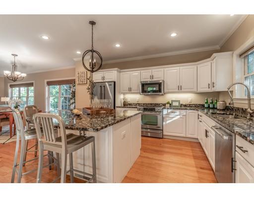 2 Farmer Road Arlington, MA 02476 - Photo 9 of 26 a kitchen with stainless steel appliances granite countertop a stove top oven a sink dishwasher a dining table and chairs with wooden floor