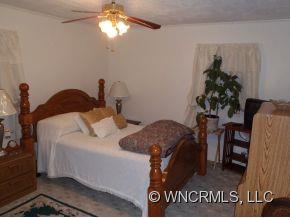 295 Roper Loop Road Rutherfordton, NC 28139 - Photo 8 of 12 a bedroom with a bed and a chandelier