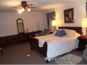 295 Roper Loop Road Rutherfordton, NC 28139 - Photo 9 of 12 a bedroom with a bed and a chandelier