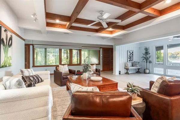 a living room with furniture a ceiling fan and a rug