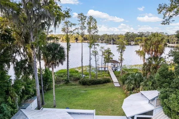 a large white kitchen with cabinets and a large window