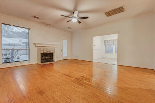 a view of empty room with wooden floor and fireplace
