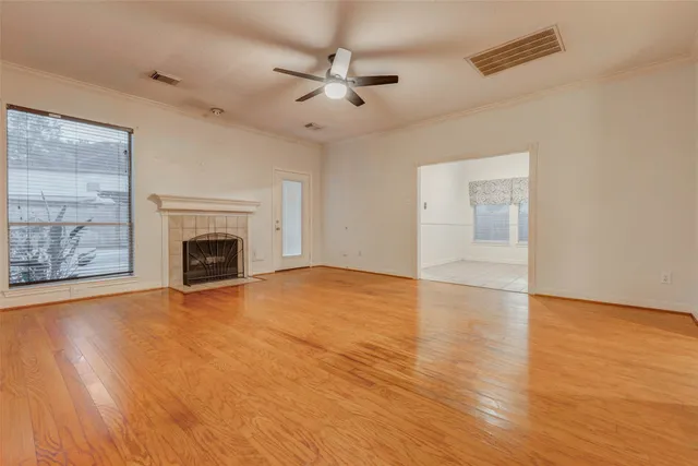 a view of empty room with wooden floor and fireplace