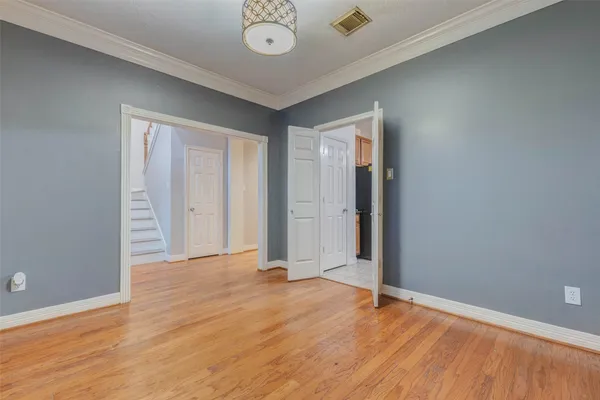 an empty room with wooden floor and mirror