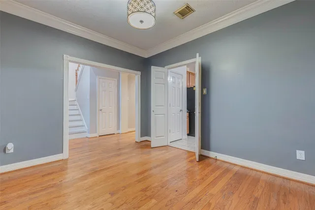 an empty room with wooden floor and mirror