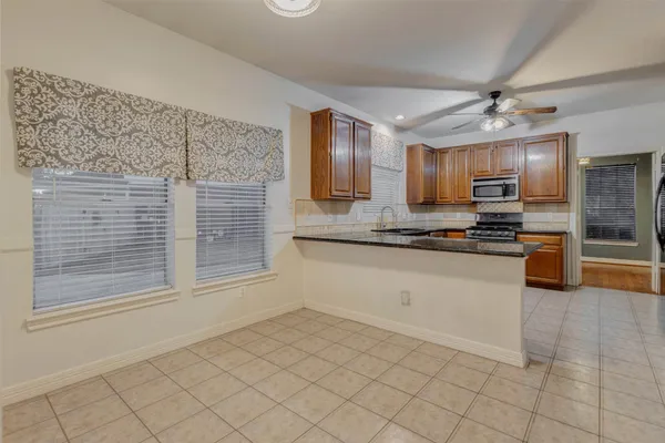 a kitchen with granite countertop a sink stainless steel appliances and cabinets