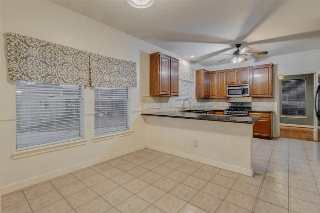 a kitchen with granite countertop a sink stainless steel appliances and cabinets