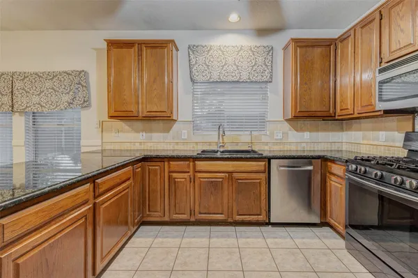 a kitchen with stainless steel appliances granite countertop a sink stove and cabinets