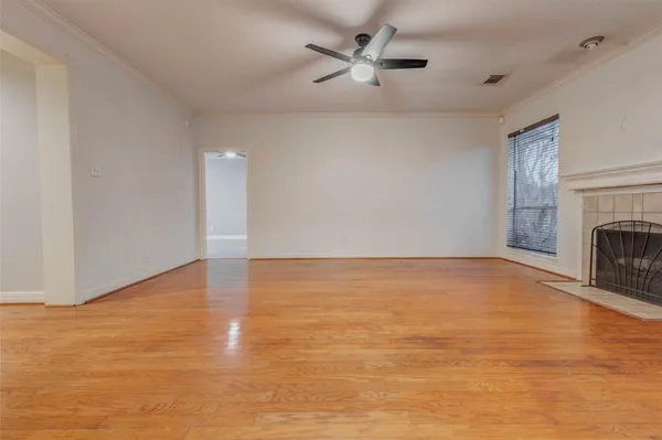a view of empty room with fan and fireplace