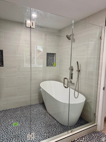 8965 Quail Run Drive Sandy, UT 84093 - Photo 46 of 56 Glass-enclosed wet room featuring a freestanding soaking tub, pebble tile flooring, and light grey subway tile walls