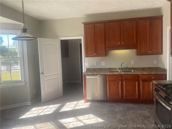 a kitchen with stainless steel appliances granite countertop a refrigerator a stove a sink and dishwasher