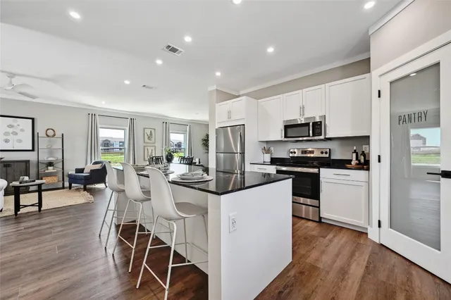 a kitchen with white cabinets and stainless steel appliances