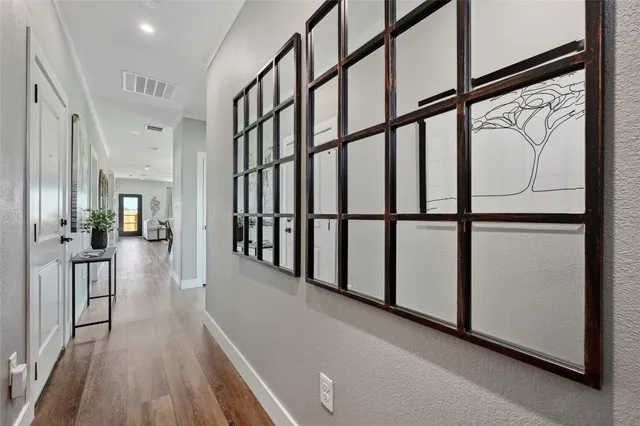 a view of staircase with lots of frames on wall and a wooden floor