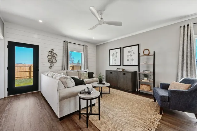 a living room with furniture a window and wooden floor
