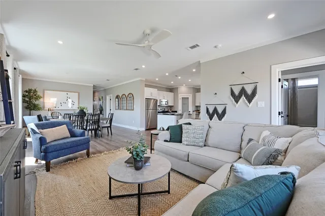 a living room with furniture kitchen view and a rug