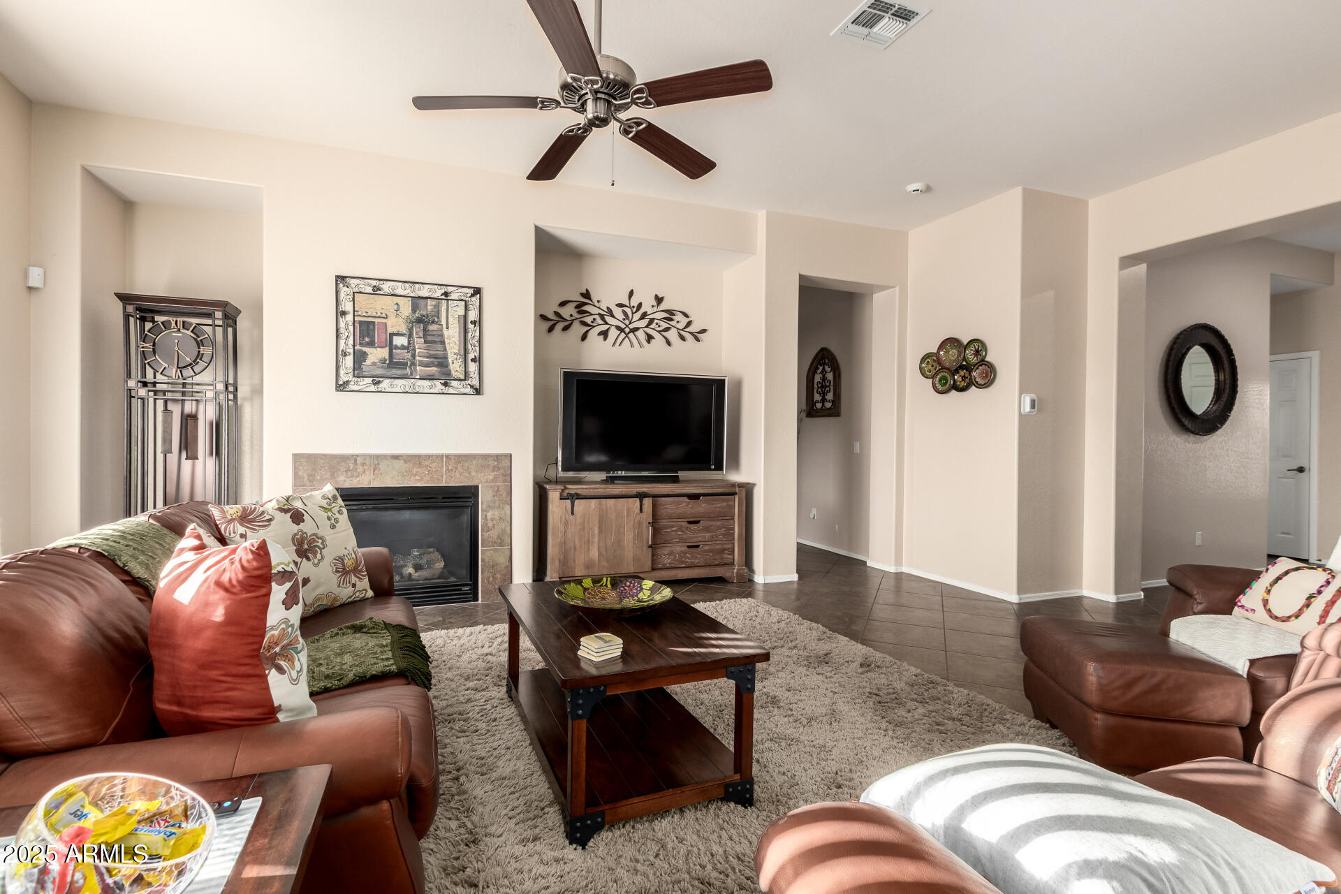 18115 West Desert View Lane Goodyear, AZ 85338 - Photo 12 of 57 a living room with furniture a flat screen tv and a fireplace