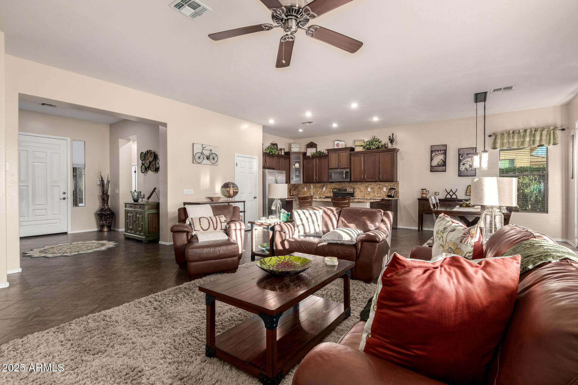 18115 West Desert View Lane Goodyear, AZ 85338 - Photo 13 of 57 a living room with furniture kitchen view and a chandelier