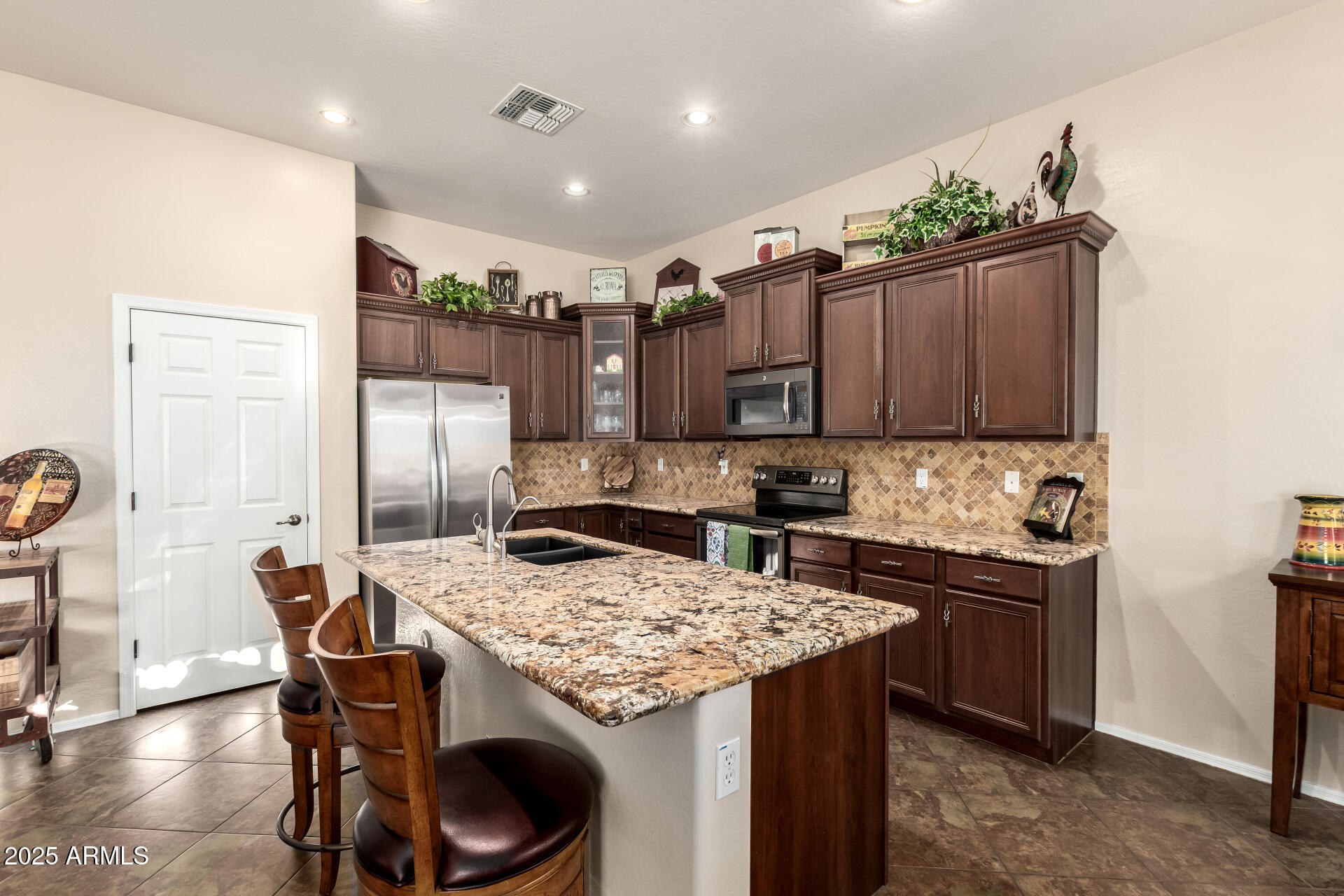 18115 West Desert View Lane Goodyear, AZ 85338 - Photo 14 of 57 a kitchen with granite countertop a table chairs stove and refrigerator