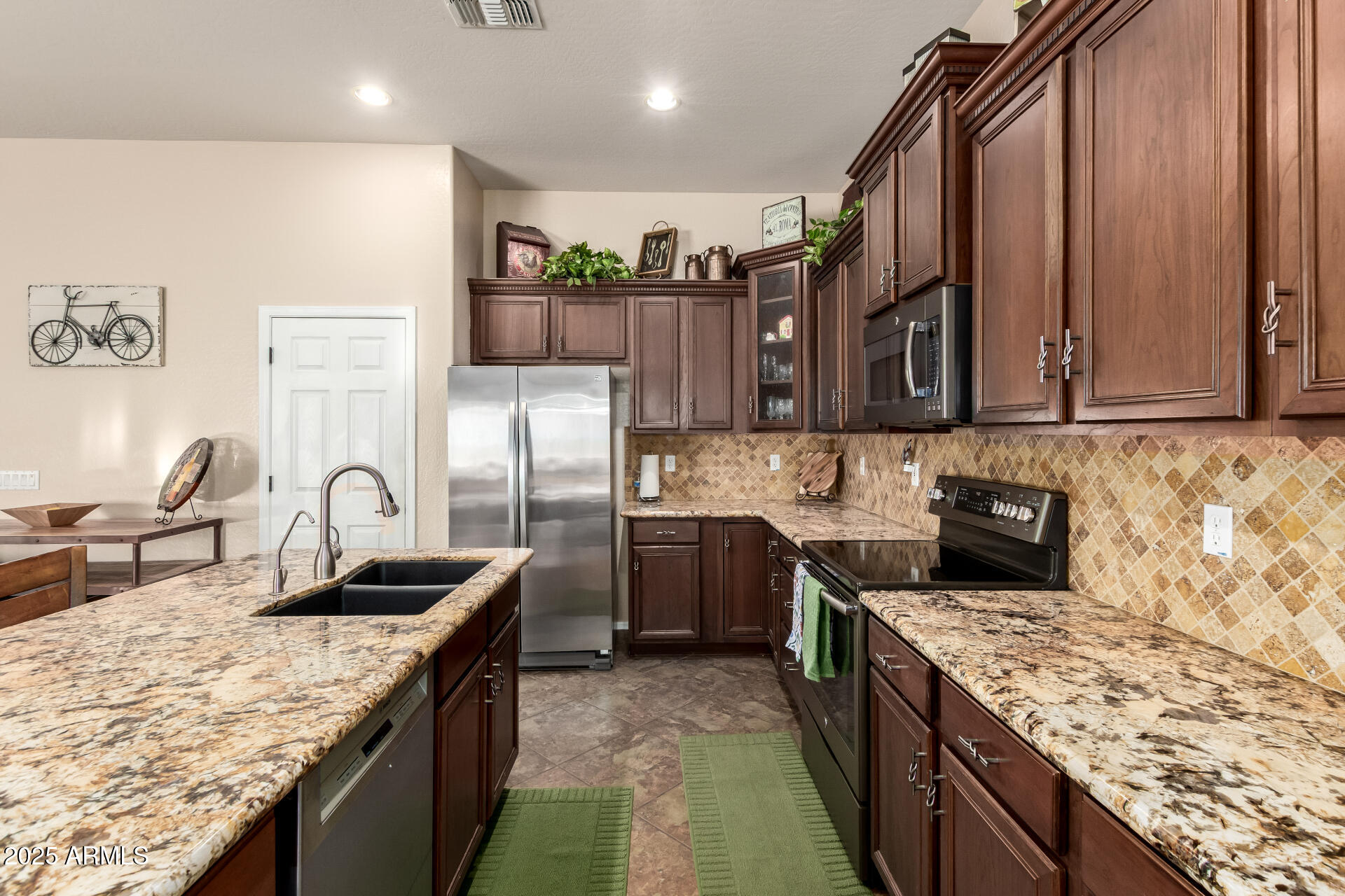 18115 West Desert View Lane Goodyear, AZ 85338 - Photo 15 of 57 a kitchen with stainless steel appliances granite countertop a sink stove and refrigerator