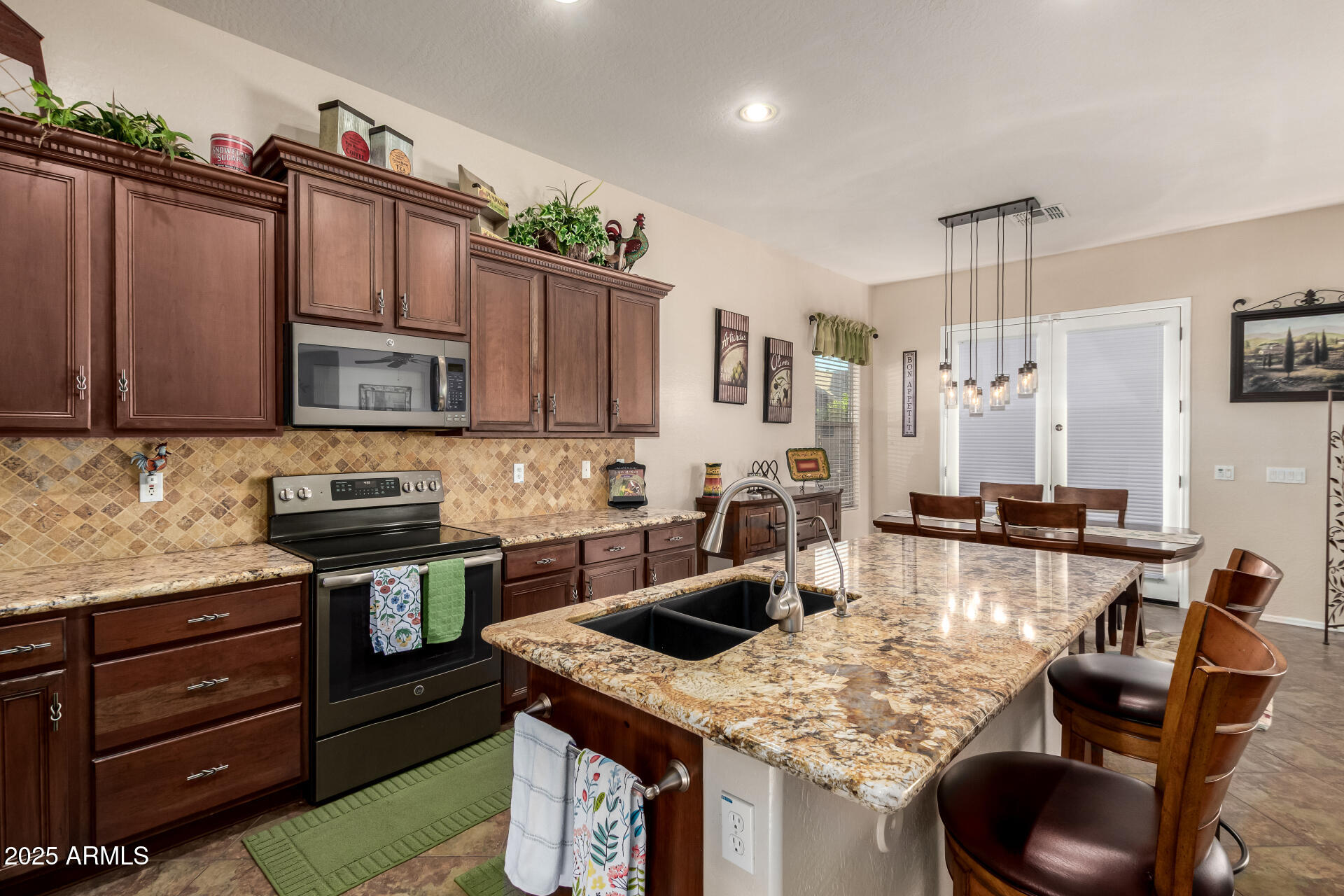 18115 West Desert View Lane Goodyear, AZ 85338 - Photo 16 of 57 a kitchen with stainless steel appliances granite countertop a sink stove and refrigerator