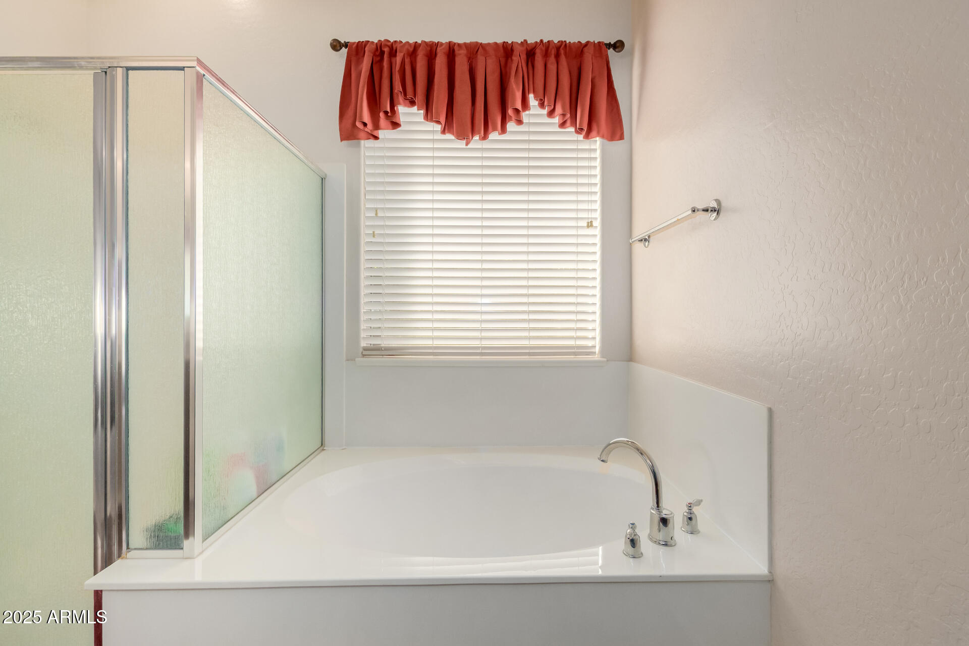 18115 West Desert View Lane Goodyear, AZ 85338 - Photo 22 of 57 a bathroom with a bathtub and a window