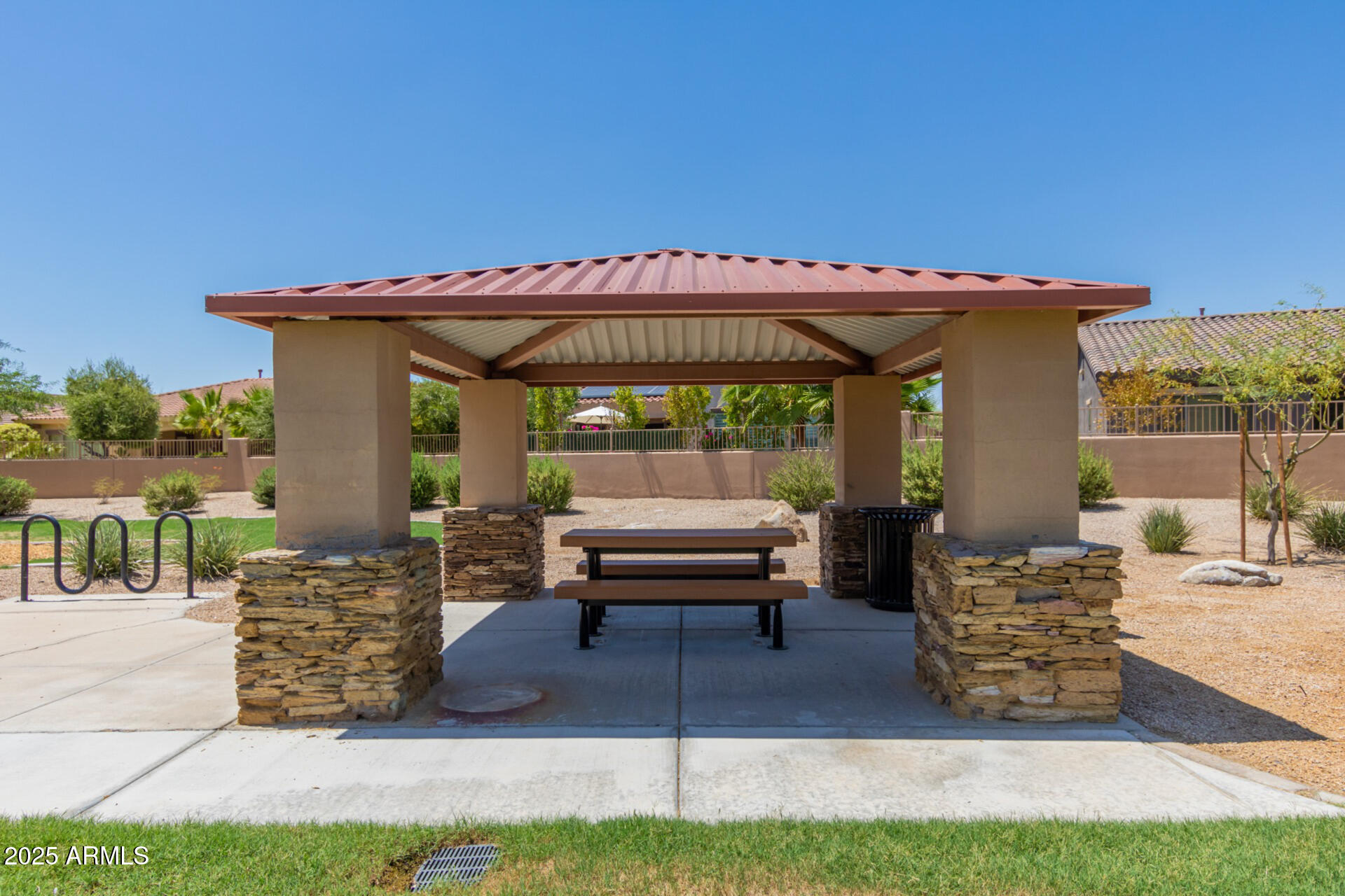 18115 West Desert View Lane Goodyear, AZ 85338 - Photo 54 of 57 a wooden bench sitting in front of a building