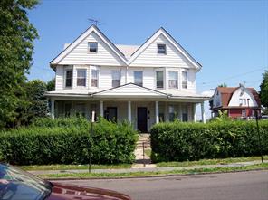 a front view of a house with a yard and potted plants