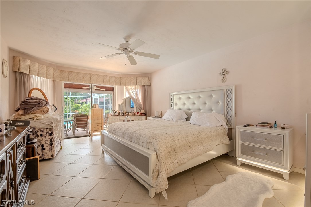 7181 Appleby Drive Naples, FL 34104 - Photo 14 of 29 a bedroom with a bed and a chandelier