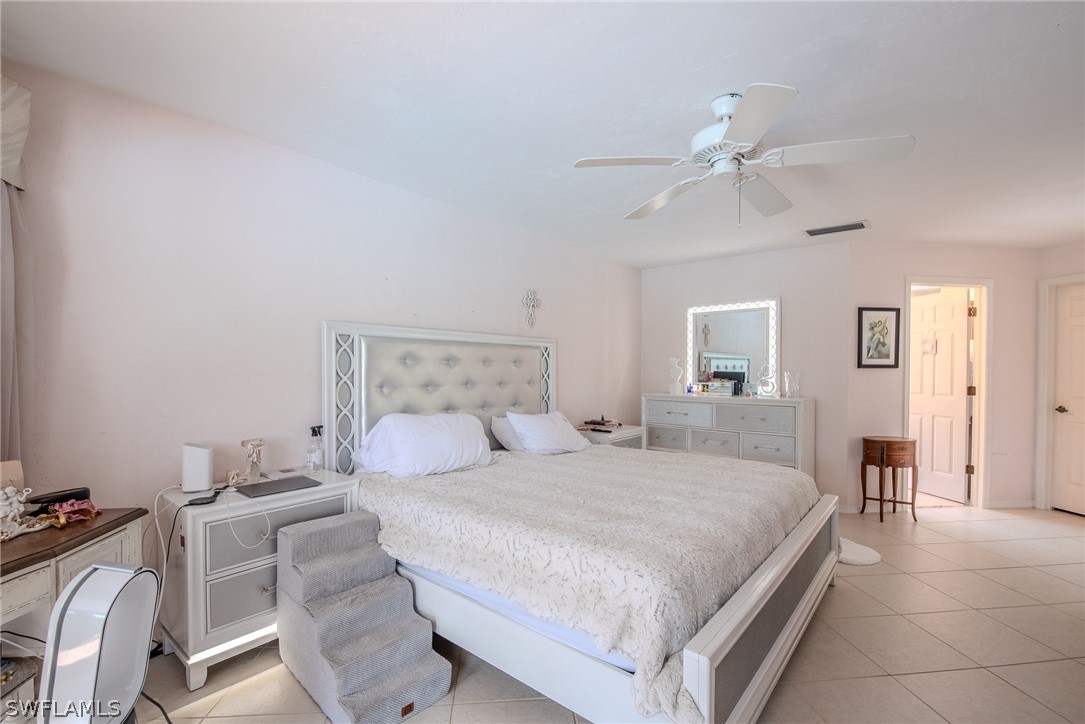 7181 Appleby Drive Naples, FL 34104 - Photo 16 of 29 a bedroom with a bed and a chandelier