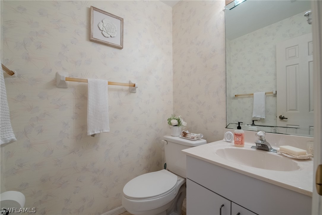 7181 Appleby Drive Naples, FL 34104 - Photo 22 of 29 a bathroom with a sink toilet and a mirror