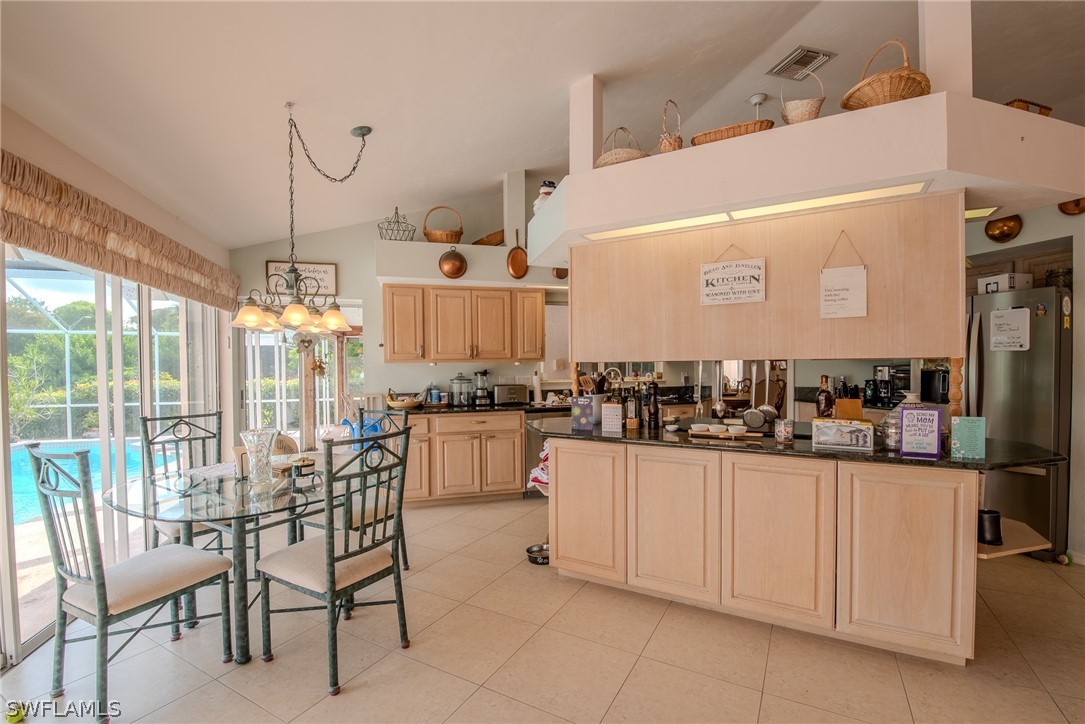 7181 Appleby Drive Naples, FL 34104 - Photo 9 of 29 a kitchen with white cabinets and chairs