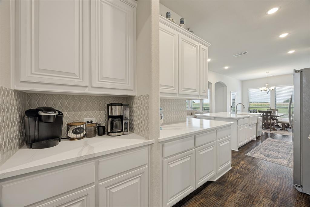 8795 County Road 502 Blue Ridge, TX 75424 - Photo 5 of 33 Kitchen featuring white cabinetry, light-toned countertops, a farmhouse-style sink with a gooseneck faucet, a built-in cooktop, and a decorative tile backsplash
