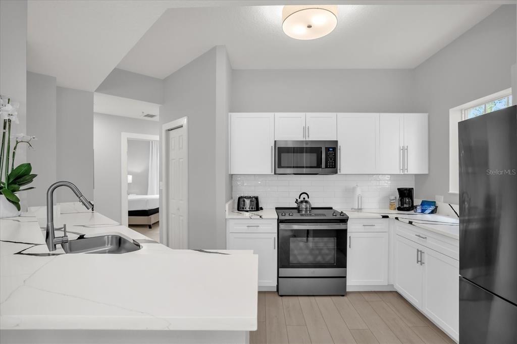8774 Worldquest Boulevard Orlando, FL 32821 - Photo 17 of 35 a kitchen with a sink appliances and cabinets