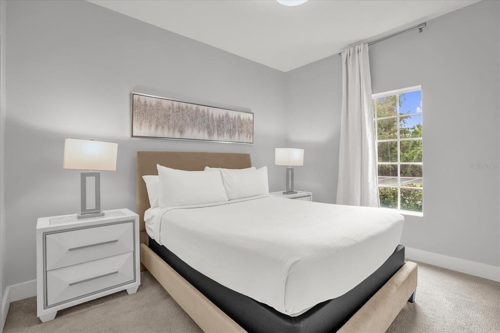 8774 Worldquest Boulevard Orlando, FL 32821 - Photo 23 of 35 a bedroom with a bed and a lamp