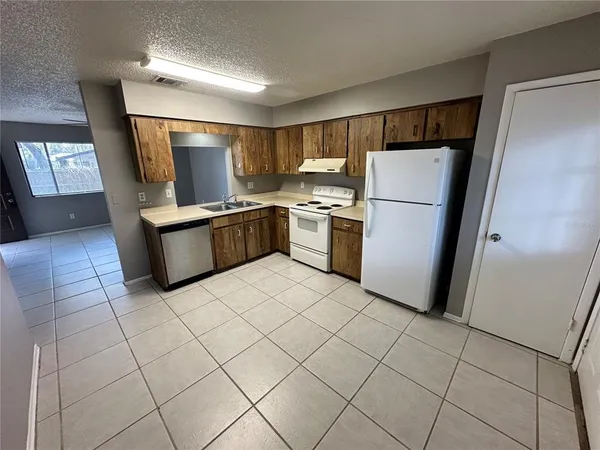 a kitchen with a refrigerator and a stove top oven