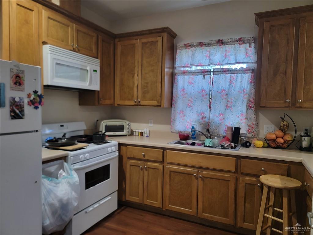 113 Spears Street San Benito, TX 78586 - Photo 7 of 15 a kitchen with cabinets a sink and white stainless steel appliances