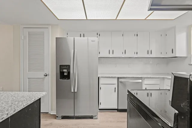 a kitchen with stainless steel appliances granite countertop a refrigerator and a sink