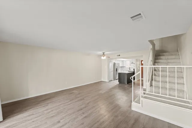 an empty room with wooden floor and fireplace