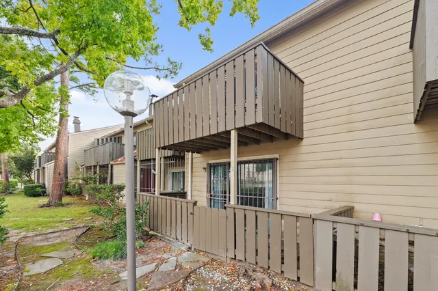a view of a house with a small yard and wooden fence
