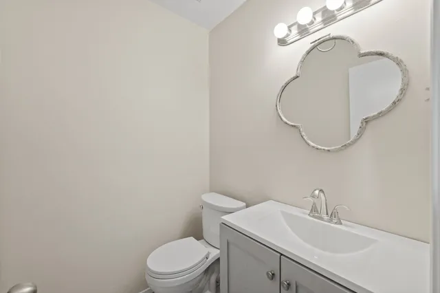 a bathroom with a sink a toilet and a mirror