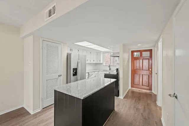 a kitchen with kitchen island a counter top space a sink and cabinets