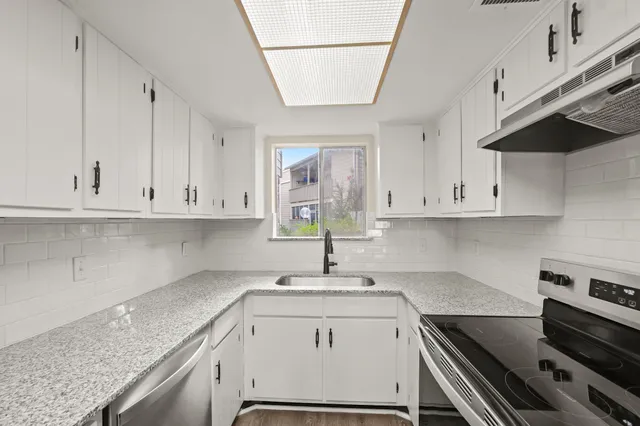 a kitchen with a sink stove and cabinets