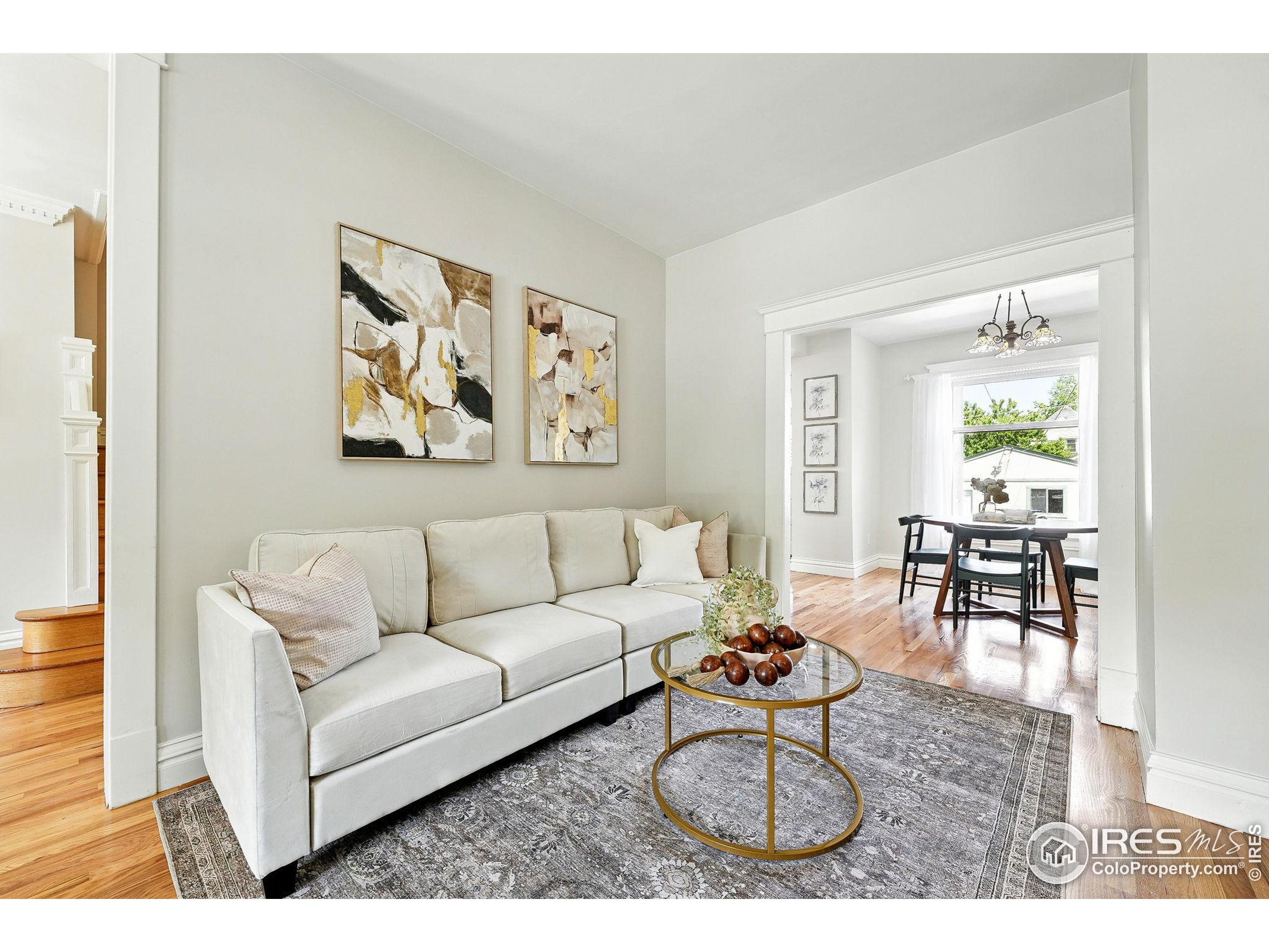 1582 Steele Street Denver, CO 80206 - Photo 12 of 48 a living room with furniture a rug and a painting on the wall