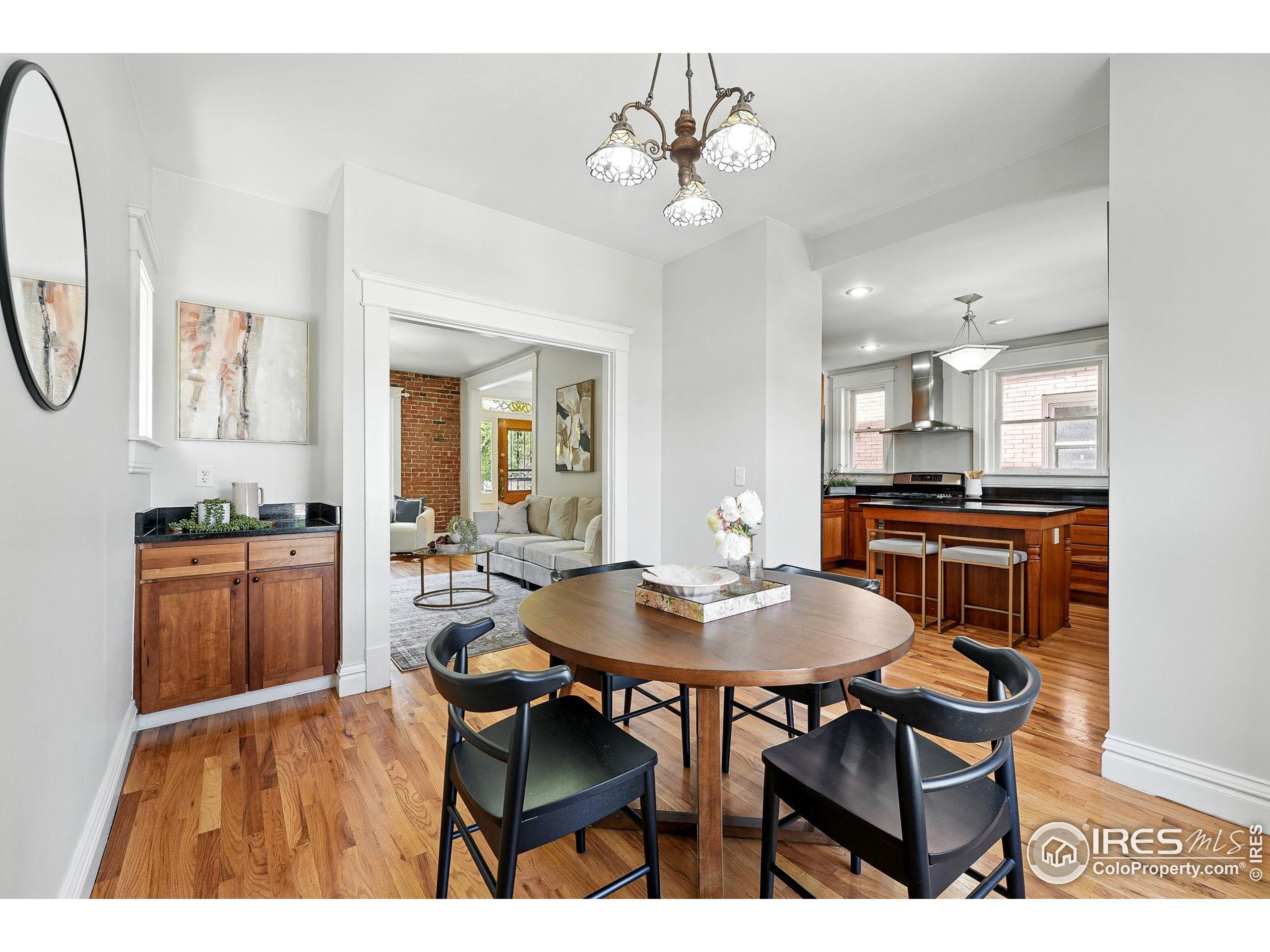 1582 Steele Street Denver, CO 80206 - Photo 13 of 48 a open dining room with kitchen island a chandelier dining table and chairs